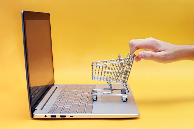 Spielzeug-Einkaufswagen auf Laptop