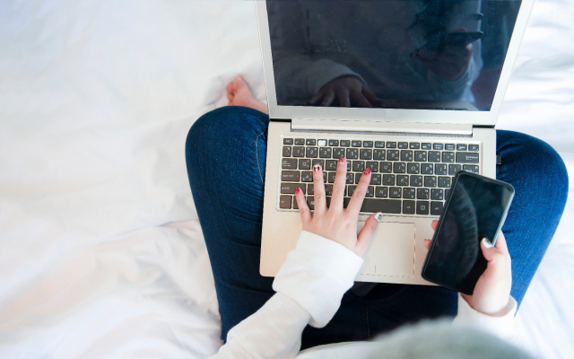 Person mit Laptop und Handy