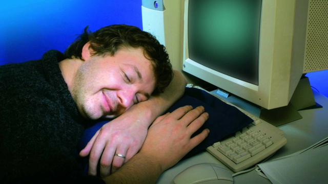 Mann schläft auf PC-Tastatur