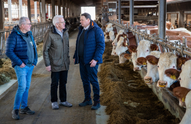 Winfried Kretschmann (M, Bündnis 90/Die Grünen), Ministerpräsident von Baden-Württemberg, besucht den Bio-Bauernhof Grieshaber & Schmid und spricht im Kuhstall mit den Inhabern Gerhard Schmid (l) und Reinhard Grieshaber (r) über die aktuellen Themen der Landwirtschaft. Bildquelle: picture alliance/dpa | Christoph Schmidt