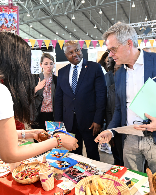 Staatssekretär Hoogvliet und Außenminister Shingiro stehen an einem der Stände auf der Fair Handeln Messe.