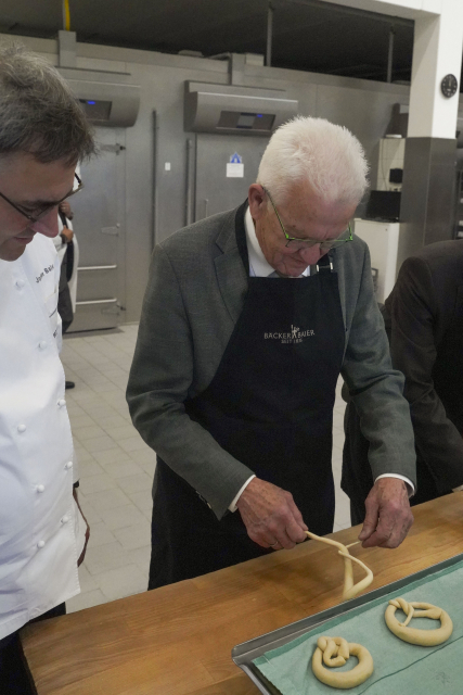 Ministerpräsident Winfried Kretschmann formt eine Brezel in der Backstube der Bäckerei Baier in Herrenberg.