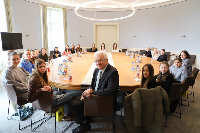 Gruppenfoto von den Teilnehmerinnen mit Ministerpräsident Kretschmann am runden Tisch im Kabinettssaal