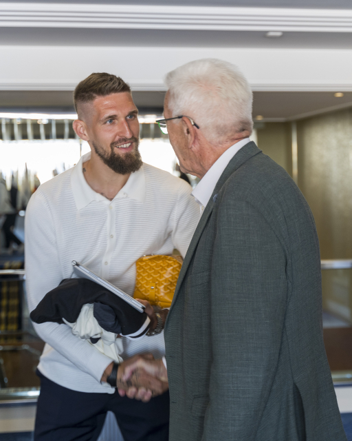 Fußball-Nationalspieler Robert Andrich begrüßt Ministerpräsident Kretschmann