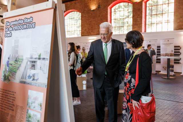 BW-Ministerpräsident Winfried Kretschmann im Gespräch mit einer Teilnehmerin beim zweiten Jahrestag des baden-württembergischen Strategiedialogs Wohnen und Bauen. © Matt Stark
