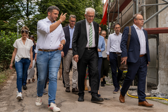 Ministerpräsident Kretschmann lässt sich vom Bürgermeister von Rudersberg, Raimon Ahrens, die Hochwasser-Schäden in Schlechtbach zeigen.
