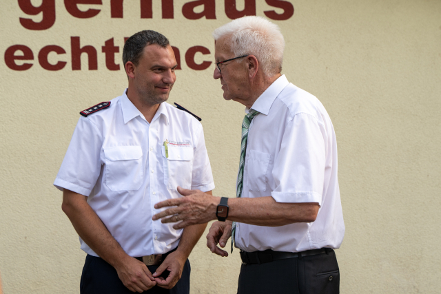 Ministerpräsident Kretschmann spricht mit dem Kommandanten der Freiwilligen Feuerwehr Rudersberg.