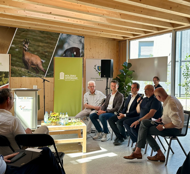 Ministerpräsident Kretschmann (links) bei einer Podiumsdiskussion mit Experten zum Thema Holzbau.