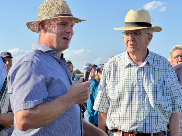 Ministerpräsident Winfried Kretschmann spricht auf der Sommertour mit einem Landwirt.