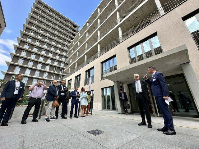 Von rechts: Carsten von Zepelin, Vorstandsvorsitzender Arlinger eG., Winfried Kretschmann, Ministerpräsident von Baden-Württemberg, und weitere Mitglieder der Arlinger eG stehen vor dem CARL Holz-Hybrid-Hochhaus in Pforzheim.