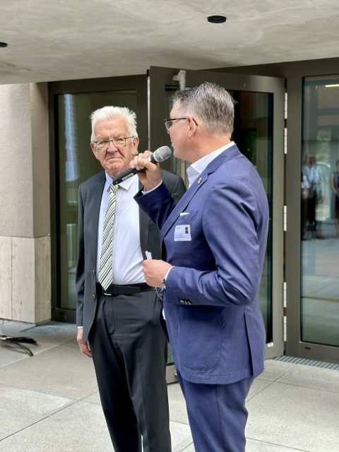 Von rechts: Carsten von Zepelin, Vorstandsvorsitzender Arlinger eG. und Winfried Kretschmann, Ministerpräsident von Baden-Württemberg, stehen vor dem CARL Holz-Hybrid-Hochhaus in Pforzheim.