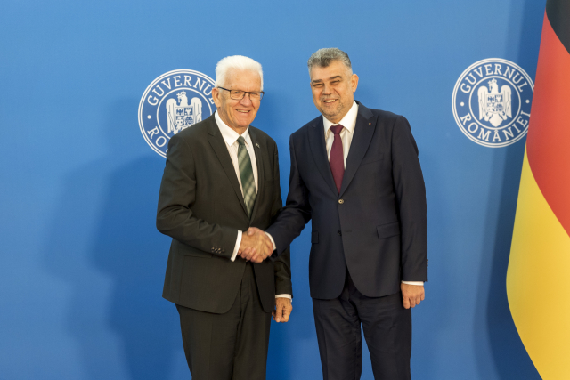 Winfried Kretschmann (links), Ministerpräsident von Baden-Württemberg, und Marcel Ciolacu (rechts), Premierminister von Rumänien, geben sich die Hand bei der Unterzeichnung der gemeinsamen Absichtserklärung um Ausbau der Beziehungen beider Länder in Bukarest. 