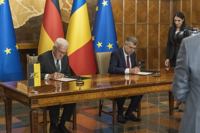 Winfried Kretschmann (links), Ministerpräsident von Baden-Württemberg, und Marcel Ciolacu (rechts), Premierminister von Rumänien, unterzeichnen die gemeinsame Absichtserklärung um Ausbau der Beziehungen beider Länder in Bukarest. 