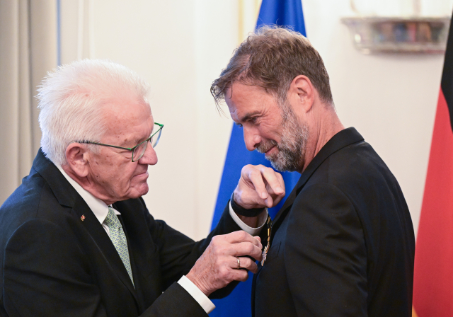 Der Fußballtrainer Jürgen Klopp (r) erhält von Winfried Kretschmann (Bündnis 90/Die Grünen), Ministerpräsident von Baden-Württemberg, den Verdienstorden des Landes Baden-Württemberg. Der gebürtige Stuttgarter erhielt die Auszeichnung für sein vielfältiges soziales Engagement abseits des Sports. Bildnachweis: picture alliance/dpa | Bernd Weißbrod