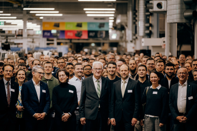 Gruppenbild: Ministerpräsident Winfried Kretschmann mit Mitarbeitenden in der Produktionshalle. Foto: Staatsministerium BW | Ilkay Karakurt