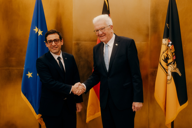 Links Stéphane Séjourné von der EU-Kommission schüttelt Ministerpräsident Winfried Kretschmann (rechts) die Hand. Im Hintergrund sind eine EU-Fahne, eine Deutschlandfahne und eine Baden-Württemberg-Fahne zu sehen.
Bildnachweis: Staatsministerium BW / Ilkay Karakurt