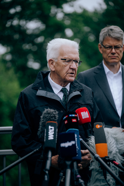 Ministerpräsident Kretschmann vor vielen Presse-Mikros am Rande der Zugunglücksstelle bei Riedlingen. 
 Quelle: Staatsministerium Baden-Württemberg /Ilkay Karakurt