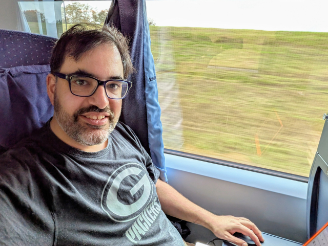 Selfie von Keywan, der im ICE sitzt und in die Kamera lächelt