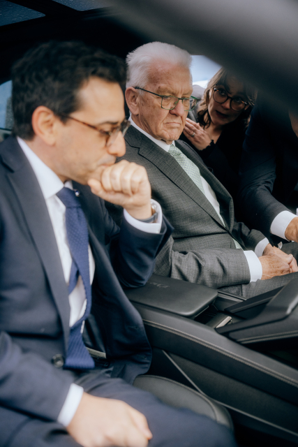 Ministerpräsident Kretschmann sitzt neben EU-Vizepräsident Séjourné im Auto. Beide schauen konzentriert in eine Richtung.
