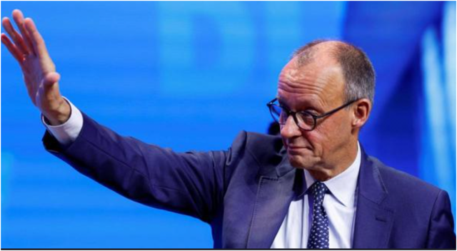 Merz hebt den rechten Arm. Nicht ganz so gestreckt wie Musk, aber ähnlich.