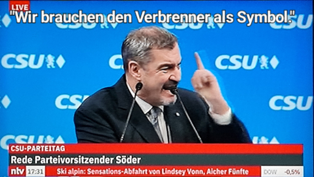 Söder mit erhobenem Zeigefinger, am Rednerpult bei Parteitag, spruch: wir brauchen den verbrenner als Symbol. 